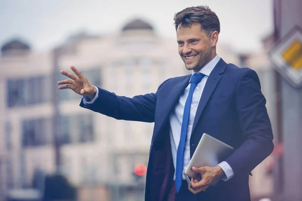 Handsome businessman hailing taxi — Stock Photo, Image