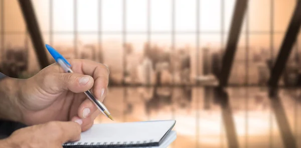 Man writing in spiral book — Stock Photo, Image