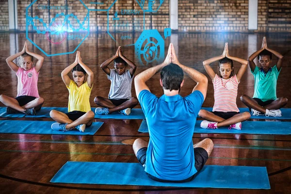 Skolebørn mediterer under yoga klasse - Stock-foto