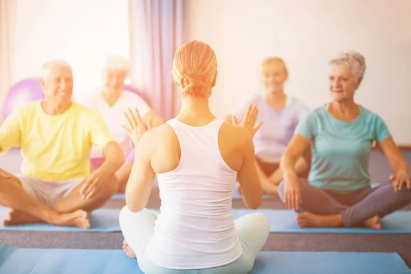 Instructor realizando yoga con personas mayores — Foto de Stock