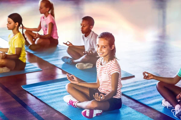 Enfants de l'école méditant pendant le cours de yoga — Photo