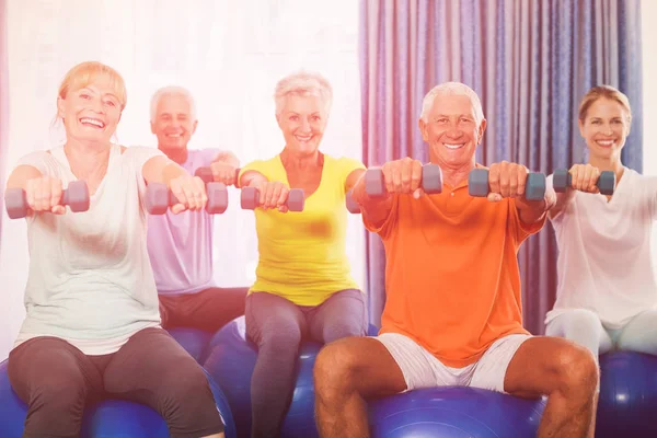 Portrait of seniors using exercise ball and weights — Stock Photo, Image