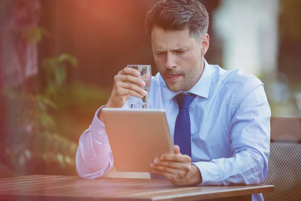 Empresário beber água enquanto estiver usando tablet digital — Fotografia de Stock