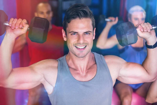 Portrait d'homme souriant soulevant haltère dans la salle de gym — Photo