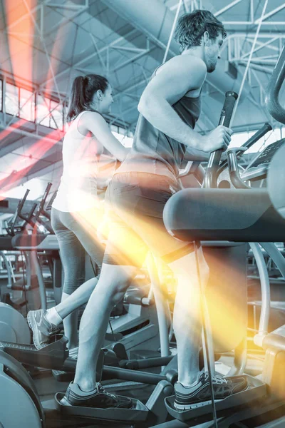 Güzel kadın ve erkek üzerinde eliptik makinesi egzersiz — Stok fotoğraf