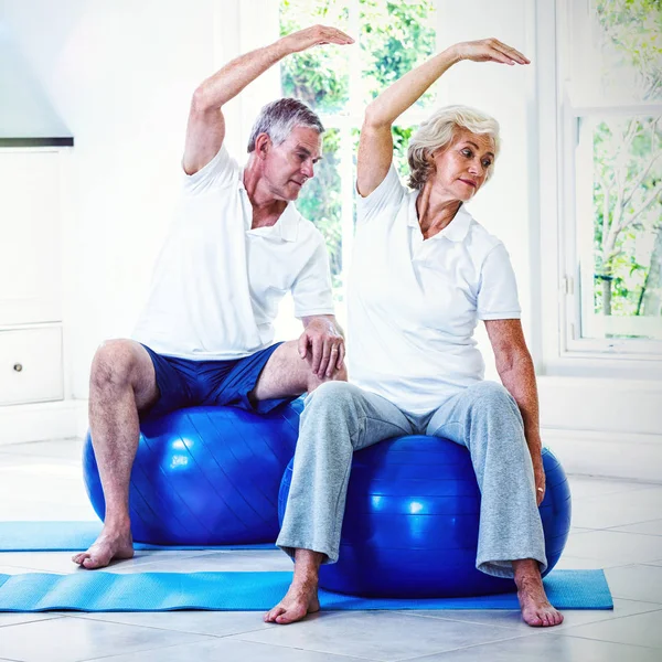 Coppia facendo aerobica sulla palla a casa — Foto Stock