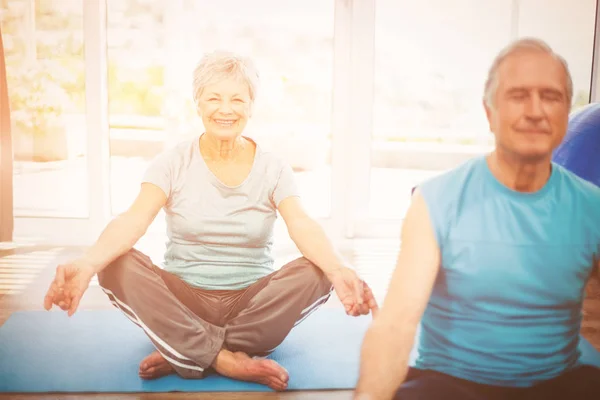 Retrato de mulher sênior sorridente com marido meditando — Fotografia de Stock