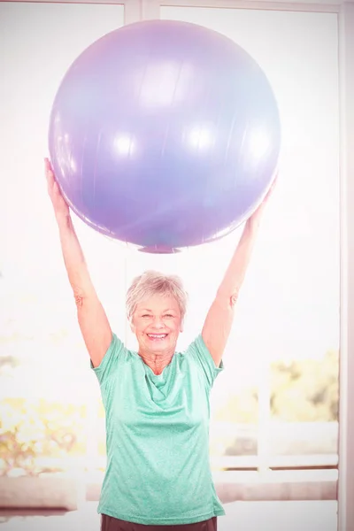Frau hält blauen Übungsball zu Hause — Stockfoto