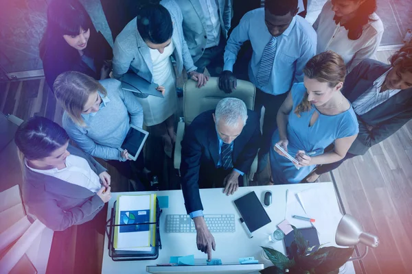 Businessman discussing with colleagues over computer — Stock Photo, Image