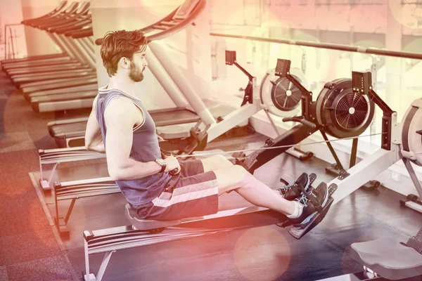 Handsome man doing exercise on drawing machine — Stock Photo, Image