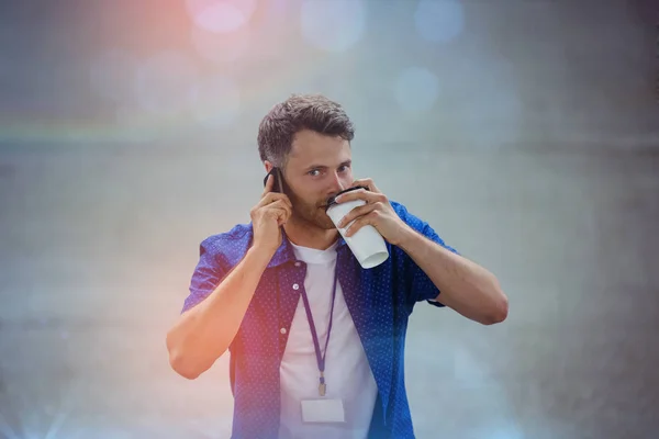 Vista de ángulo alto del hombre bebiendo café mientras habla en el teléfono móvil —  Fotos de Stock