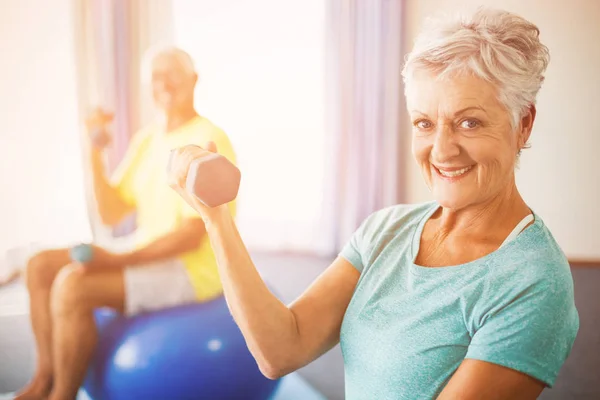 Idosos usando bola de exercício e pesos — Fotografia de Stock