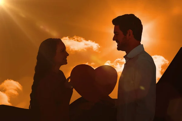 Smiling couple holding paper heart — Stock Photo, Image