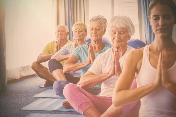 Idosos relaxando com instrutor de fitness — Fotografia de Stock