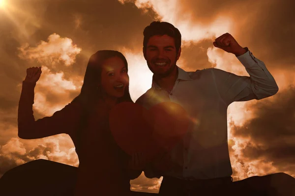 Cheerful couple holding paper heart — Stock Photo, Image