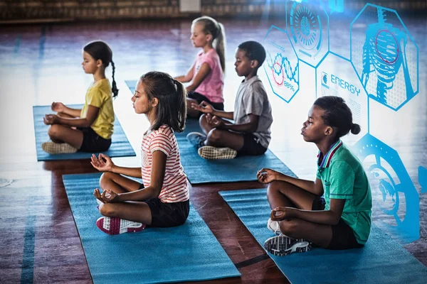 Дети в школе медитируют во время занятий йогой — стоковое фото