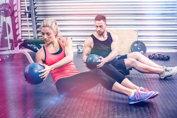 Ajuste pareja haciendo ejercicio de pelota abdominal — Foto de Stock