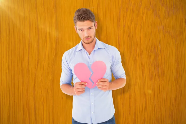 Triste hombre sosteniendo un corazón roto —  Fotos de Stock