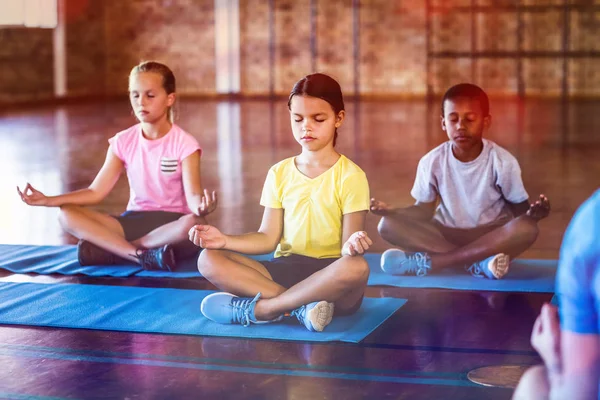 Skolbarnen mediterar under yogaklass — Stockfoto