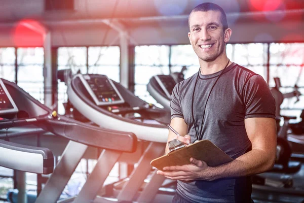 Entrenador muscular escribir en el portapapeles — Foto de Stock