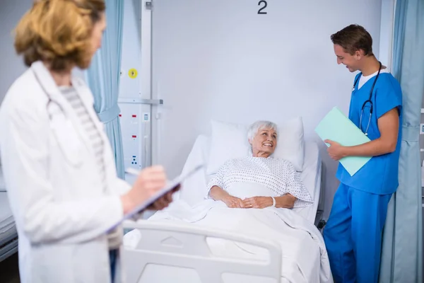 Ärzte im Gespräch mit einem älteren Patienten — Stockfoto