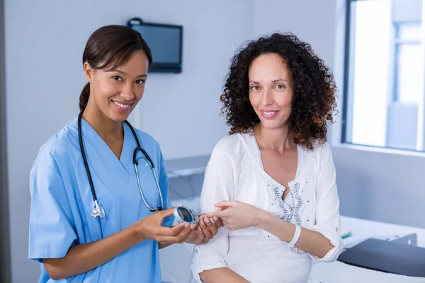 Portrait of doctor examining pregnant womans blood sugar — Stock Photo, Image