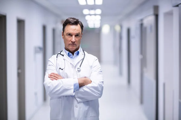 Retrato de un médico de pie con los brazos cruzados en el pasillo —  Fotos de Stock