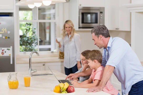 Papà e i suoi figli usano il portatile mentre fanno colazione — Foto Stock