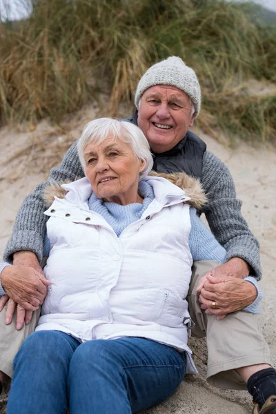 Seniorenpaar sitzt zusammen am Strand — Stockfoto