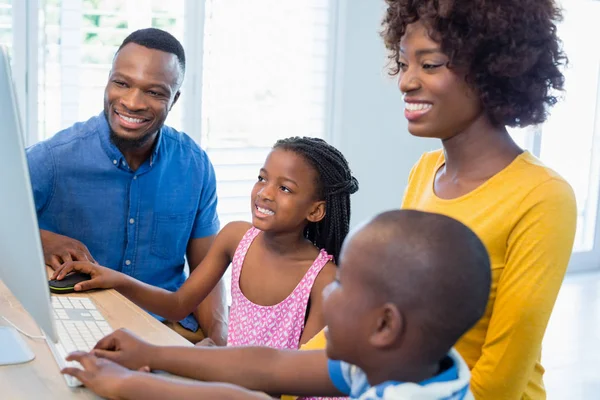 Família feliz usando computador na sala de estar — Fotografia de Stock