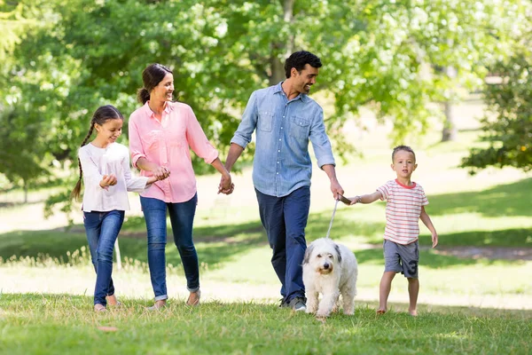 Familj njuter tillsammans med sin hund i parken — Stockfoto