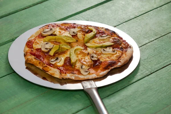 Heerlijke Italiaanse pizza geserveerd op pizza peel — Stockfoto