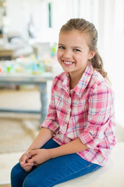 Lachende schattig meisje zittend op tafel — Stockfoto