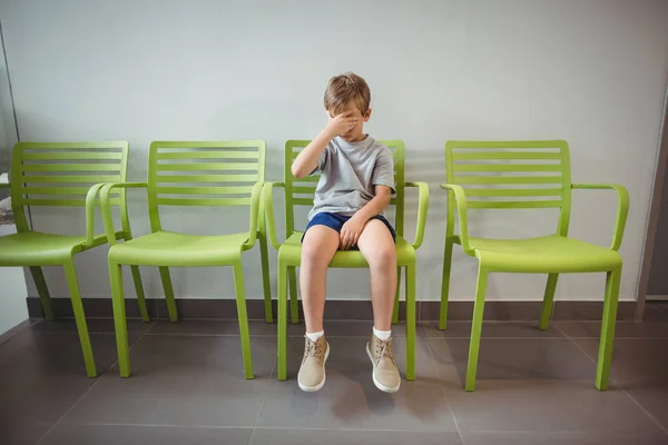 Aufgebrachter Junge sitzt auf Stuhl im Flur — Stockfoto