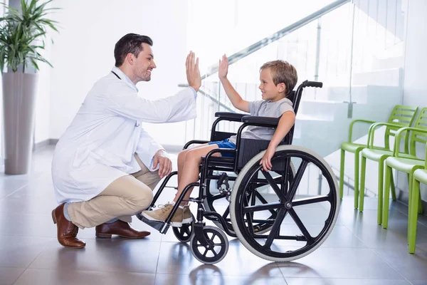 Doctor giving high five to disable boy — Stock Photo, Image
