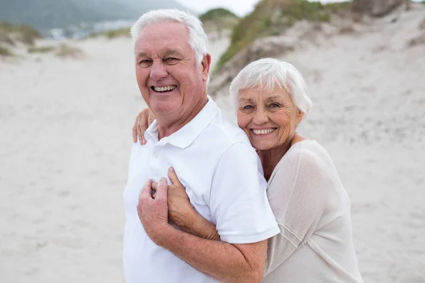 Coppia di anziani che si abbracciano sulla spiaggia — Foto Stock