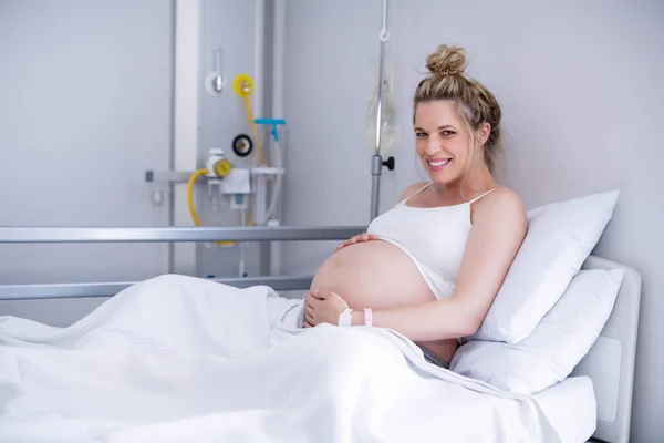 Retrato de mulher grávida relaxando na cama do hospital — Fotografia de Stock