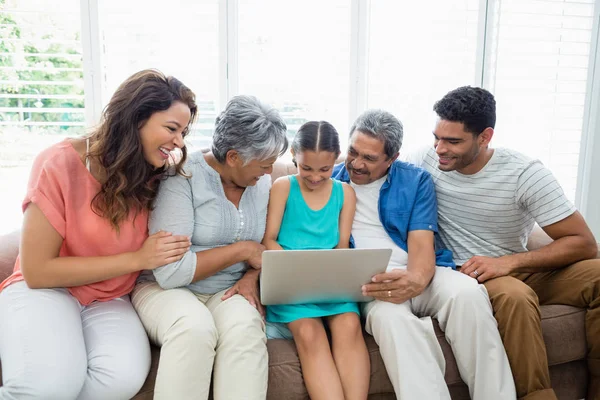 Щаслива багатовимірна сім'я використовує ноутбук у вітальні — стокове фото