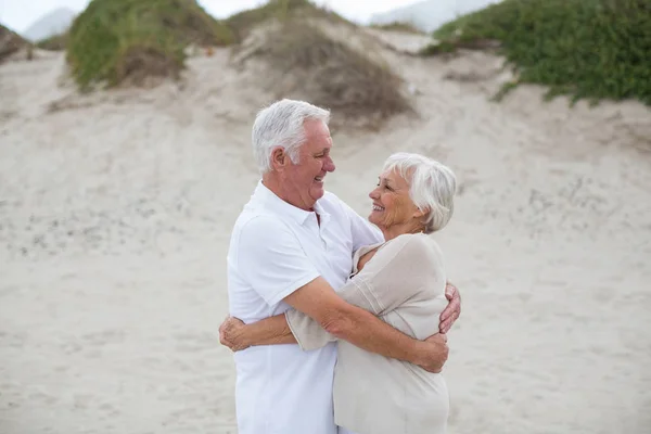 Seniorenpaar umarmt sich am Strand — Stockfoto