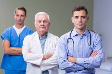 Portrait of doctors standing with arms crossed clipart