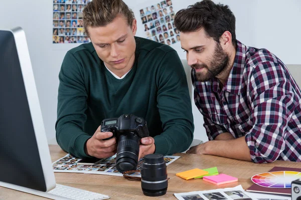 Fotógrafos revisando fotos capturadas en cámara digital — Foto de Stock