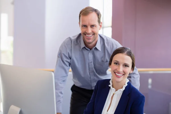 Businesswoman working at desk with colleague — Stock Photo, Image