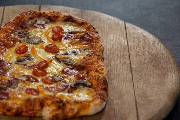 Deliciosa pizza italiana servida sobre tabla de madera — Foto de Stock