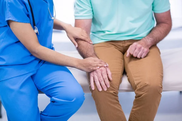 Mid section of doctor consoling senior patient — Stock Photo, Image