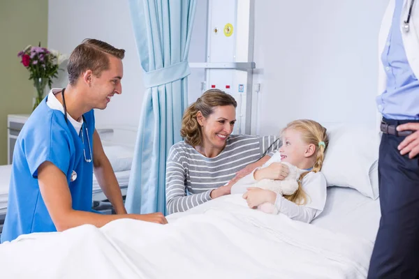 Врач разговаривает с пациентом и матерью в палате больницы — стоковое фото