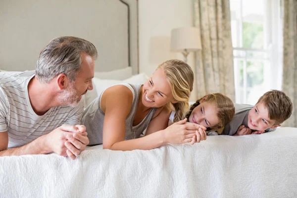 Föräldrar med sina barn liggande på sängen i sovrummet — Stockfoto