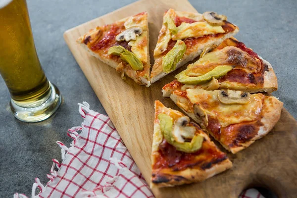 Trozos de pizza italiana servidos con un vaso de cerveza — Foto de Stock