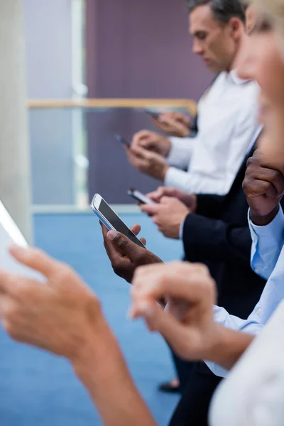 Executivos de empresas usando tablet digital e telefone celular — Fotografia de Stock