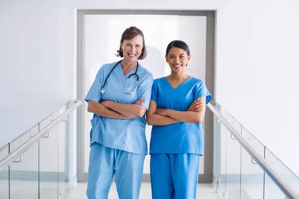 Porträtt av leende sjuksköterska och läkare står med armarna korsade — Stockfoto