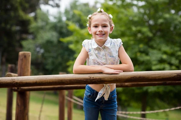 Ragazza in piedi su un parco giochi giro nel parco — Foto Stock